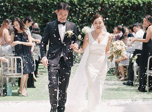 bride and groom covered in confetti during ceremony