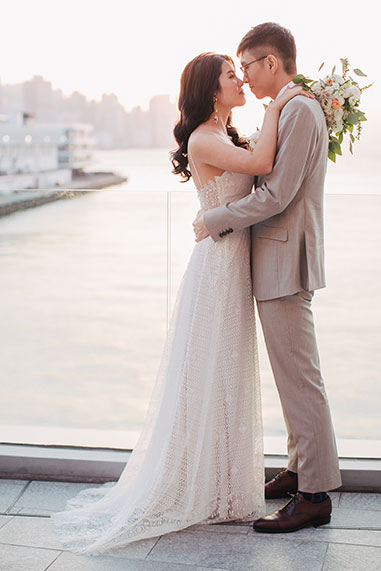 bride and groom hug in front of the seas in hong kong